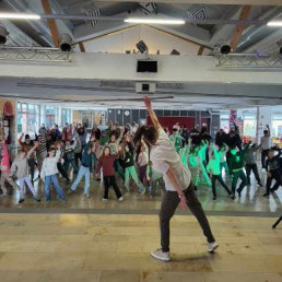 Gro&szlig;e Sch&uuml;lergruppe tanzt gemeinsam in der Aula zum neuen Schultanz.