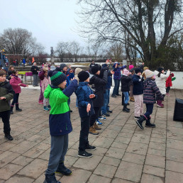 Schulfamilie führt auf dem Pausenhof Tanzbewegungen in der Pause synchron aus. Training ist alles ...